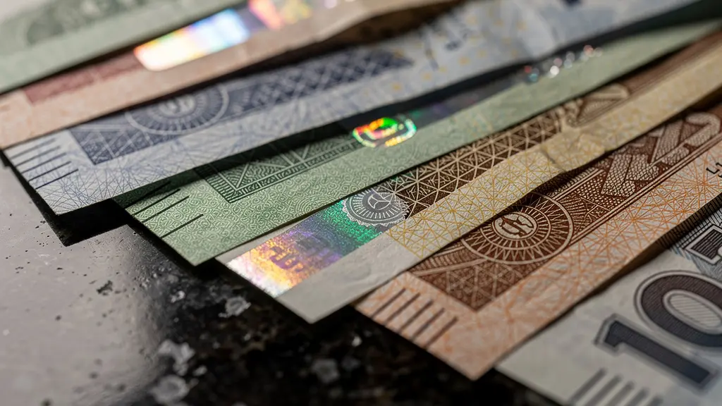 Billets de différentes devises fortes arrangés en éventail sur surface en marbre